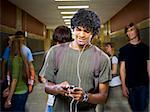 High School boy at school listening to MP3 player.