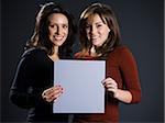 two women holding a sign