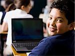 garçon avec un ordinateur portable à l'école