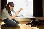 woman playing with dog in living room