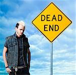 man looking at a dead end sign