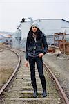 Woman Standing on Railroad Tracks in Urban Industrial Area, Portland, Oregon, USA