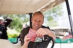 Mann mit Punktekarte im Golf-Cart