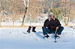 Man Sitting on Snow, Changing into Ice Skates and Holding Hockey Stick, Fuschl am See, Salzburg, Austria