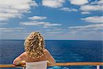 Femme regardant l'océan de l'arrière du bateau de croisière