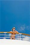 Woman Wearing Bikini Leaning on Railing of Cruise Ship