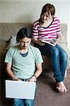 Jeune couple avec livre et ordinateur portable