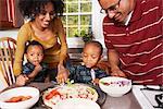 Familie in der Küche machen eine Pizza