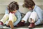 Two little girls sitting on ground and playing