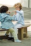 Girls playing clapping game on bench