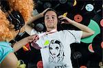 Man Lying on Pile of Records, Woman Pulling Him Up By His Necktie