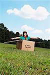 Boy Playing in Cardboard Box