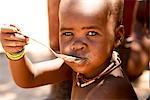 Himba junge Essen, Opuwo, Namibia