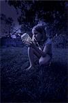 Girl Looking at Jar of Fireflies at Night