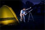 Vater und Sohn Camping im Hinterhof bei Nacht, Blick durchs Teleskop