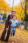Mutter stossend Sohn auf Swing im Park, Portland, Oregon, USA