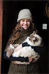 Portrait d'une jeune adolescente, tenant un chat dans une ferme de Hillsboro, Oregon, Etats-Unis