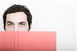 Portrait of Man Covering Face with Book