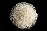 a pile of uncooked rice against a black plate