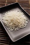 ungekocht Reiskörner auf einem quadratischen Teller