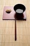 steam gyoza dumpling with sauce in bowl and chopstick on bamboo mat