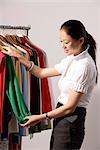 Chinese fashion designer selecting clothes from rack