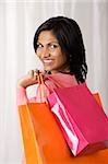 woman holding shopping bags, smiling