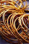 Gold indische Armreifen in lila Sari Stoff closeup