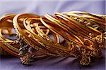 gold Indian bangles on purple sari cloth