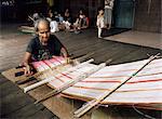 Iban woman weaving pua kumbu, in complex traditional patterns and reated to old head-hunting rituals, Katibas River, Sarawak, Malaysia, island of Borneo, Southeast Asia, Asia