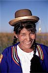 Head and shoulders portrait of a smiling Uros Indian woman, Islas Flotantes, floating islands, Lake Titicaca, Peru, South America