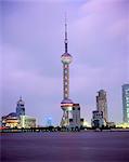 View across river at dusk to the new Pudong district skyline, Huangpu River, Shanghai, China, Asia