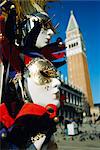 Carnival masks on souvenir stand and Campanile, St Marks Square, Venice, Veneto, Italy