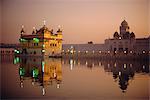 Crépuscule sur la piscine sacrée de Nectar regardant vers la tour de l'horloge et le Temple d'or, lieu Saint Sikh, Amritsar, état du Pendjab, en Inde, Asie