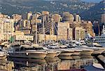 Motor cruisers at anchor and highrise buildings above the harbour, La Condamine, Monaco, Mediterranean, Europe
