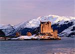 Eilean Donan castle in winter, from Ardelve Point in late afternoon with snow on the mountains round Loch Duich, Dornie, Highlands, Scotland, United Kingdom, Europe