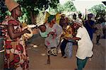 Small group of people, including woman with her baby, dancing outdoors, Gambia, West Africa, Africa
