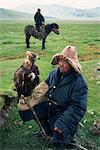 Portrait of an eagle breeder in traditional clothing, with his bird, Kazakh, Bayan-olgii, Khovd Gol valley, Mongolia, Central Asia, Asia