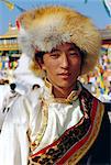 Young Tibetan man wearing typical hat and dress during Losar (Tibetan New Year) at Bodhnath, Katmandu, Nepal