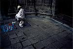 Artist crafting little dolls by church, Mexico City, Mexico, North America