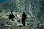 Backpackers look at the Inca ruins at Machu Picchu, UNESCO World Heritage Site, Peru, South America