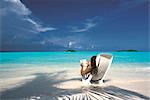 Femme lisant un livre sur la plage, Maldives, océan Indien, Asie