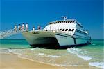 Tourists boarding large catamaran on beach near Rockhampton, Queensland, Australia, Pacific