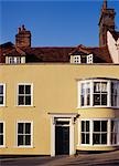 Georgian town house, cream painted plaster, bow window, dormer, casement windows behind parapet. Maldon, Essex. C18th