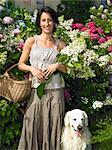 Femme avec son chien, tenant des fleurs