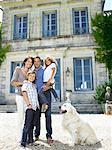 Famille debout devant une maison