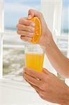 Hand squeezing orange juice