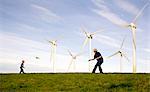 Mann, junge spielen Frisbee bei Windkraftanlagen