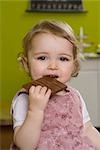 Young girl biting into chocolate bar