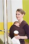 Mutter im Shop mit dem Baby im Tragetuch